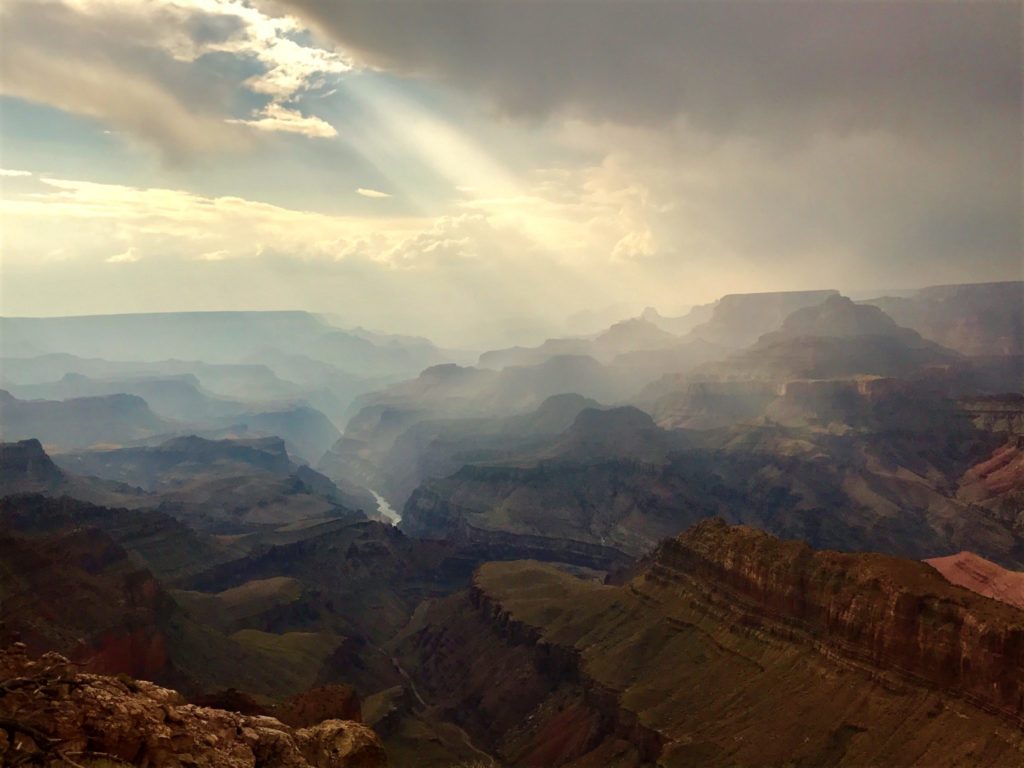 image of the Grand Canyon with a beam of sunlight coming out of the clouds