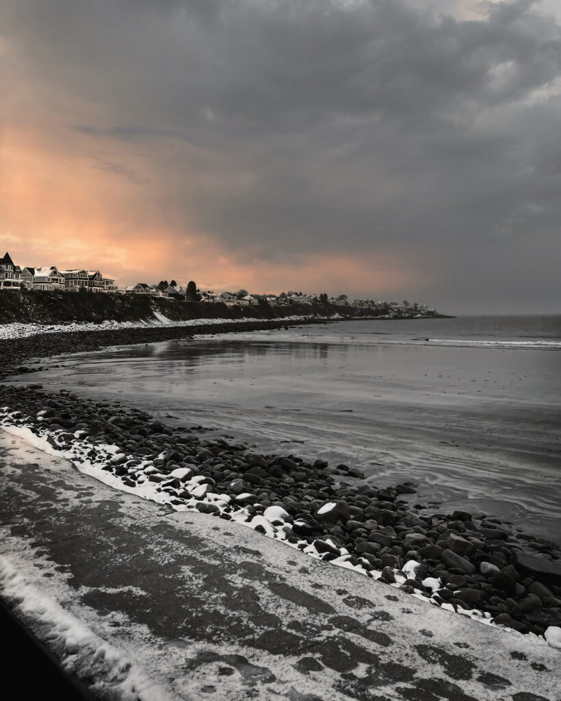 Image of an icy shoreline with homes in the background