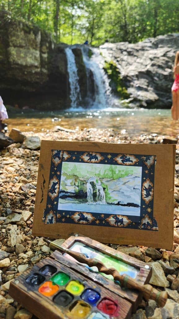 small painting of falls creek falls in front of the falls, which are seen in soft focus in the background